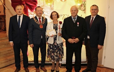 Zdjęcia z uroczystości Złotych God&oacute;w w Domu Ludowym w Zręcinie. Przedstawiają one występy męskiej sekcji Zespołu Śpiewaczego &bdquo;Chorkowianie&rdquo; w tradycyjnych strojach ludowych, oficjalne wystąpienie władz gminy Chork&oacute;wka oraz pamiątkowe kadry z jubilatami odznaczonymi Medalami za Długoletnie Pożycie Małżeńskie.