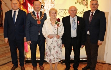 Zdjęcia z uroczystości Złotych God&oacute;w w Domu Ludowym w Zręcinie. Przedstawiają one występy męskiej sekcji Zespołu Śpiewaczego &bdquo;Chorkowianie&rdquo; w tradycyjnych strojach ludowych, oficjalne wystąpienie władz gminy Chork&oacute;wka oraz pamiątkowe kadry z jubilatami odznaczonymi Medalami za Długoletnie Pożycie Małżeńskie.