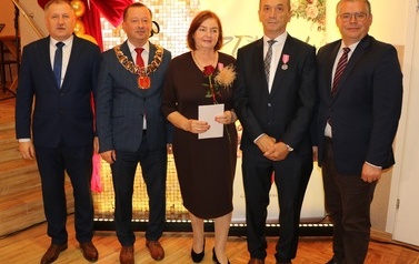 Zdjęcia z uroczystości Złotych God&oacute;w w Domu Ludowym w Zręcinie. Przedstawiają one występy męskiej sekcji Zespołu Śpiewaczego &bdquo;Chorkowianie&rdquo; w tradycyjnych strojach ludowych, oficjalne wystąpienie władz gminy Chork&oacute;wka oraz pamiątkowe kadry z jubilatami odznaczonymi Medalami za Długoletnie Pożycie Małżeńskie.