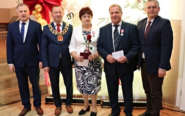 Zdjęcia z uroczystości Złotych God&oacute;w w Domu Ludowym w Zręcinie. Przedstawiają one występy męskiej sekcji Zespołu Śpiewaczego &bdquo;Chorkowianie&rdquo; w tradycyjnych strojach ludowych, oficjalne wystąpienie władz gminy Chork&oacute;wka oraz pamiątkowe kadry z jubilatami odznaczonymi Medalami za Długoletnie Pożycie Małżeńskie.