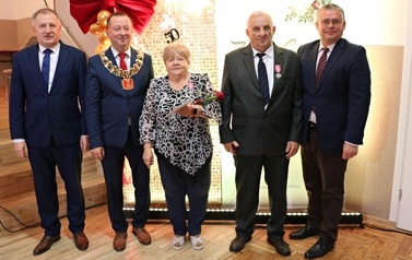 Zdjęcia z uroczystości Złotych God&oacute;w w Domu Ludowym w Zręcinie. Przedstawiają one występy męskiej sekcji Zespołu Śpiewaczego &bdquo;Chorkowianie&rdquo; w tradycyjnych strojach ludowych, oficjalne wystąpienie władz gminy Chork&oacute;wka oraz pamiątkowe kadry z jubilatami odznaczonymi Medalami za Długoletnie Pożycie Małżeńskie.