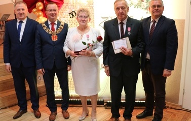 Zdjęcia z uroczystości Złotych God&oacute;w w Domu Ludowym w Zręcinie. Przedstawiają one występy męskiej sekcji Zespołu Śpiewaczego &bdquo;Chorkowianie&rdquo; w tradycyjnych strojach ludowych, oficjalne wystąpienie władz gminy Chork&oacute;wka oraz pamiątkowe kadry z jubilatami odznaczonymi Medalami za Długoletnie Pożycie Małżeńskie.