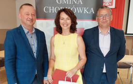 Na zdjęciu Ewa Machowska odbierająca nagrodę w imieniu c&oacute;rki,  W&oacute;jt Gminy Chork&oacute;wka oraz zastępca na tle banneru z herbem gminy. 