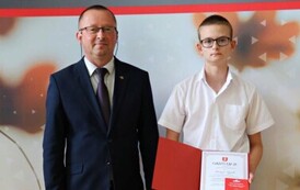 Na zdjęciu laureaci nagr&oacute;d w&oacute;jta gminy Chork&oacute;wka za osiągnięcie wysokich wynik&oacute;w w nauce. Uczniowie pozują na tle ścianki z herbem gminy w towarzystwie pana w&oacute;jta oraz dyrektor&oacute;w swoich szk&oacute;ł. 