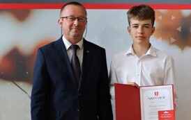 Na zdjęciu laureaci nagr&oacute;d w&oacute;jta gminy Chork&oacute;wka za osiągnięcie wysokich wynik&oacute;w w nauce. Uczniowie pozują na tle ścianki z herbem gminy w towarzystwie pana w&oacute;jta oraz dyrektor&oacute;w swoich szk&oacute;ł. 