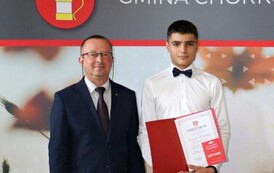 Na zdjęciu laureaci nagr&oacute;d w&oacute;jta gminy Chork&oacute;wka za osiągnięcie wysokich wynik&oacute;w w nauce. Uczniowie pozują na tle ścianki z herbem gminy w towarzystwie pana w&oacute;jta oraz dyrektor&oacute;w swoich szk&oacute;ł. 