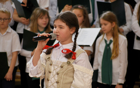 Akademia szkolna z okazji Dnia Patrona szkoły. Ch&oacute;r mieszany w biało-czarnych strojach.  