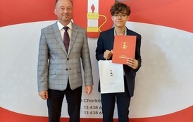 Nagrodzony uczeń w towarzystwie w&oacute;jta. 