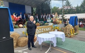 Konferansjer w ciemnym garniturze. 