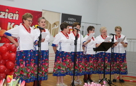 Na scenie kobiety w strojach ludowych. obok akordeonista. 