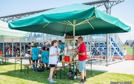 Zdjęcie wsp&oacute;łorganizator&oacute;w. Ich stoiska pod namiotami. 