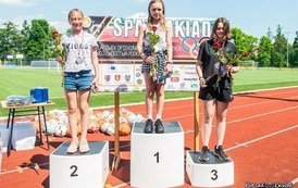 Podium i na nim nagrodzeni sportowcy. 