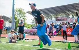 Skok w worku. Zdjęcie uczestnik&oacute;w Spartakiady wykonane na murawie boiska. 