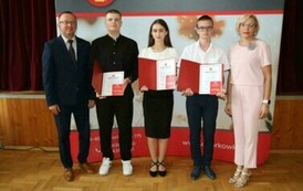 Na zdjęciu laureaci nagr&oacute;d w&oacute;jta gminy Chork&oacute;wka za osiągnięcie wysokich wynik&oacute;w w nauce. Uczniowie pozują na tle ścianki z herbem gminy w towarzystwie pana w&oacute;jta oraz dyrektor&oacute;w swoich szk&oacute;ł. 