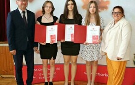 Na zdjęciu laureaci nagr&oacute;d w&oacute;jta gminy Chork&oacute;wka za osiągnięcie wysokich wynik&oacute;w w nauce. Uczniowie pozują na tle ścianki z herbem gminy w towarzystwie pana w&oacute;jta oraz dyrektor&oacute;w swoich szk&oacute;ł. 