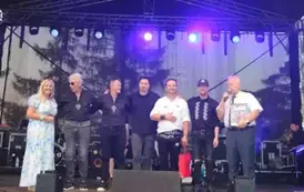 Na scenie zar&oacute;wno zesp&oacute;ł jak i prowadzący, kt&oacute;rzy wręczają podziękowanie. 