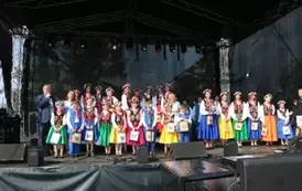 Dzieci zar&oacute;wno chłopcy jak i dziewczynki w strojach ludowych występują na scenie. 