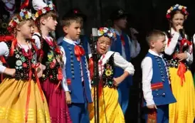 Dzieci zar&oacute;wno chłopcy jak i dziewczynki w strojach ludowych występują na scenie. 