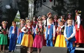 Dzieci zar&oacute;wno chłopcy jak i dziewczynki w strojach ludowych występują na scenie. 