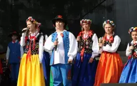 Dzieci zar&oacute;wno chłopcy jak i dziewczynki w strojach ludowych występują na scenie. 