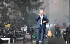 Konferansjer w garniturze na scenie. 