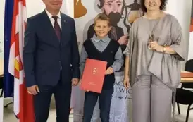 Stypendysta w towarzystw w&oacute;jta i pani dyrektor. Zdjęcie po odebraniu nagrody. 