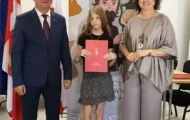 Stypendystka w towarzystw w&oacute;jta i pani dyrektor. Zdjęcie po odebraniu nagrody. 