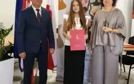 Stypendystka w towarzystw w&oacute;jta i pani dyrektor. Zdjęcie po odebraniu nagrody. 