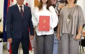 Stypendystka w towarzystw w&oacute;jta i pani dyrektor. Zdjęcie po odebraniu nagrody. 