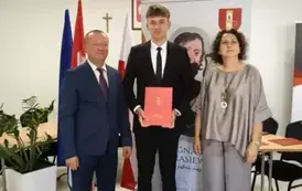 Stypendysta w towarzystw w&oacute;jta i pani dyrektor. Zdjęcie po odebraniu nagrody. 