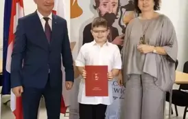 Na zdjęciu nagrodzona uczeń w towarzystwie W&oacute;jta oraz Pani dyrektor.