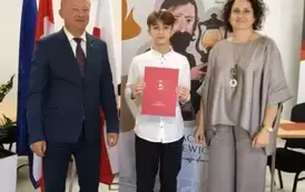 Na zdjęciu nagrodzona uczeń w towarzystwie W&oacute;jta oraz Pani dyrektor.