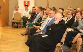 Ujęcie z boku na widownię. Wśr&oacute;d siedzących os&oacute;b widać dorosłych oraz dzieci.