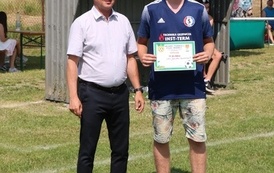 Seria dynamicznych i pozowanych zdjęć z amatorskiego turnieju piłki nożnej, kt&oacute;ry odbył się w pogodny, słoneczny dzień na trawiastym boisku otoczonym brzozami. Zdjęcia przedstawiają pełny przebieg wydarzenia sportowego. Galeria zawiera pozowane fotografie
