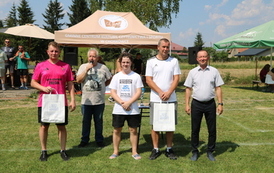 Seria dynamicznych i pozowanych zdjęć z amatorskiego turnieju piłki nożnej, kt&oacute;ry odbył się w pogodny, słoneczny dzień na trawiastym boisku otoczonym brzozami. Zdjęcia przedstawiają pełny przebieg wydarzenia sportowego. Galeria zawiera pozowane fotografie