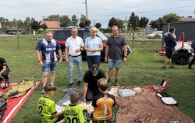 Seria fotografii dokumentujących plenerowe wydarzenie edukacyjne &bdquo;Akademia OLiOC&rdquo;, kt&oacute;re odbyło się na boisku trawiastym w Kopytowej pod patronatem Gminy Chork&oacute;wka. Zdjęcia przedstawiają praktyczne warsztaty z pierwszej pomocy przedmedycznej oraz prezenta