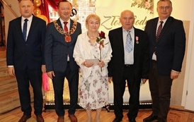 Zdjęcia z uroczystości Złotych God&oacute;w w Domu Ludowym w Zręcinie. Przedstawiają one występy męskiej sekcji Zespołu Śpiewaczego &bdquo;Chorkowianie&rdquo; w tradycyjnych strojach ludowych, oficjalne wystąpienie władz gminy Chork&oacute;wka oraz pamiątkowe kadry z jubilatami odznaczonymi Medalami za Długoletnie Pożycie Małżeńskie.