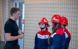 Zdjęcia przedstawiają uczestnik&oacute;w w strojach sportowych i strażackich podczas rywalizacji na hali sportowej, m.in. dynamiczne konkurencje z wężami strażackimi, uroczystą zbi&oacute;rkę wszystkich drużyn, a także momenty wręczania puchar&oacute;w, dyplom&oacute;w oraz nagr&oacute;d indywidualnych przez zaproszonych gości i przedstawicieli straży pożarnej.
