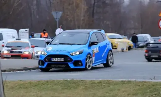 Niebieski samochód rajdowy w trakcie wyścigu rajdowego. 