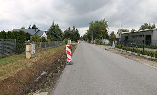 Na zdjeciu widoczna jezdnia oraz pachołki biało czerwone zabezpieczające miejsca przygotowane do remontu. 